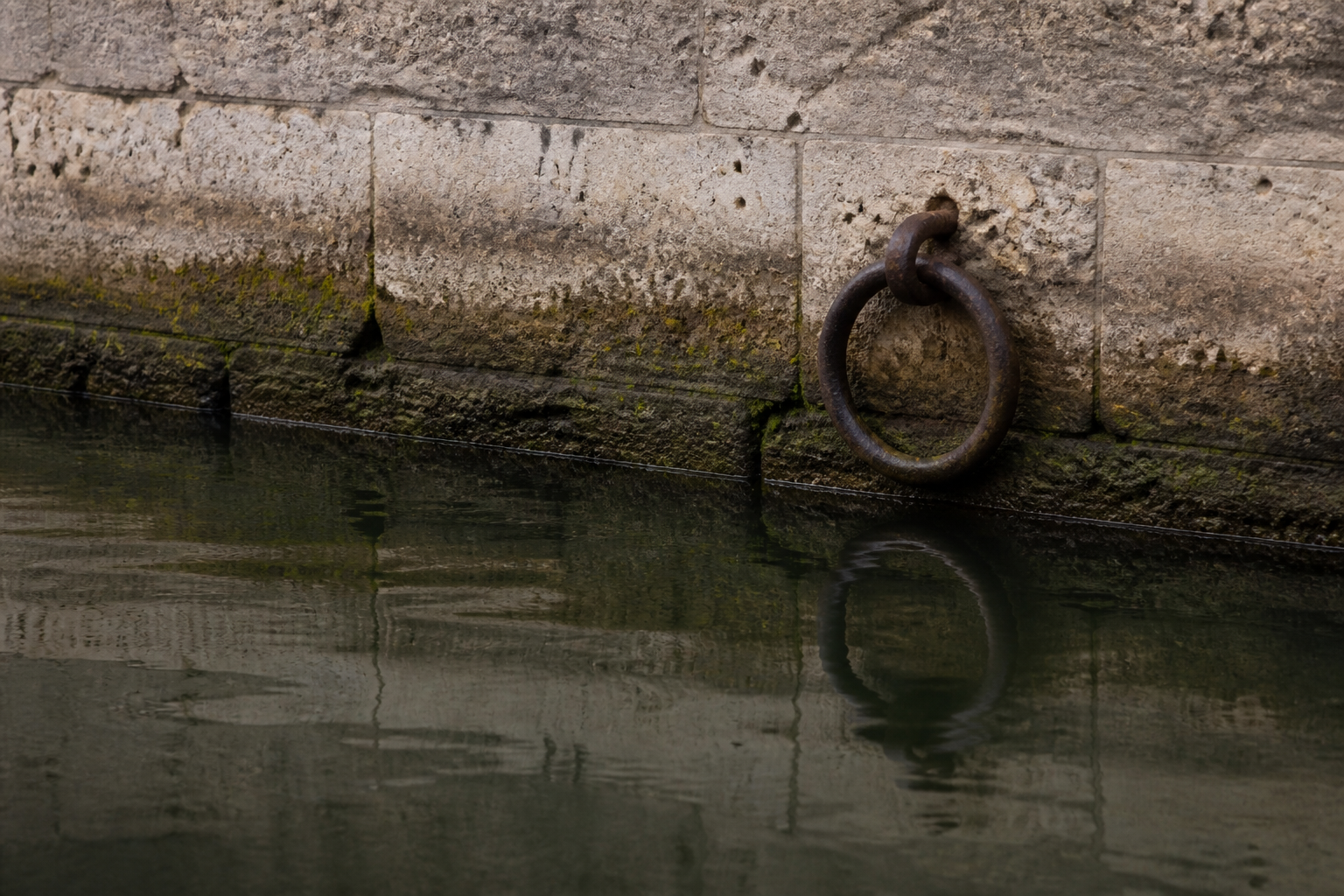 Iron mooring ring in damp limestone above still chamber water
