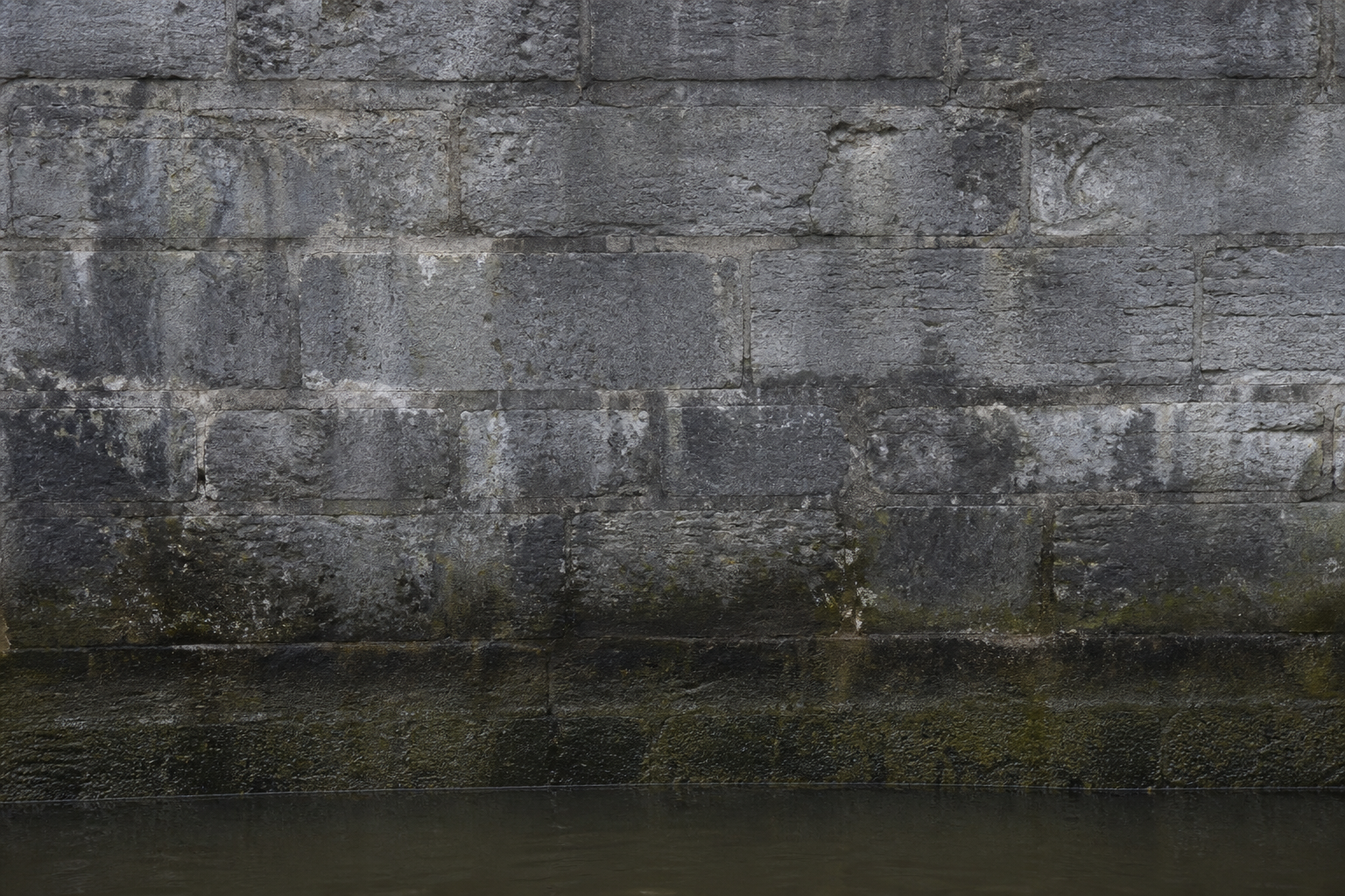 Damp grey limestone lock wall texture