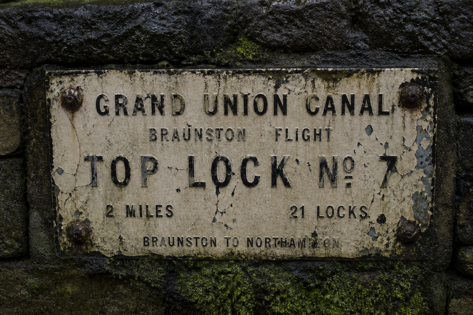 Towpath sign fragment on damp stone